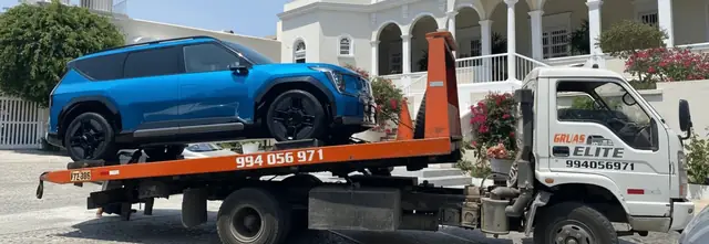 Grúa de plataforma con una camioneta azul